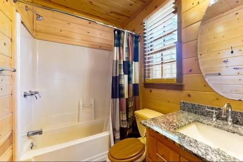 a bathroom with a tub and a toilet and a sink at Coos Moose in Ellijay