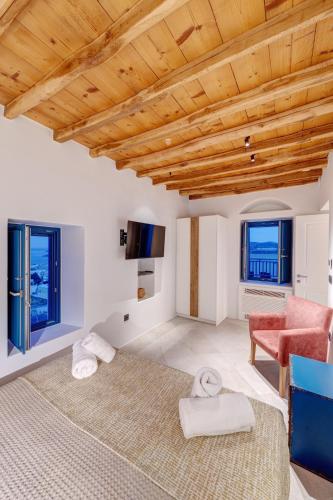 a living room with white walls and a wooden ceiling at Totem in Ano Syros