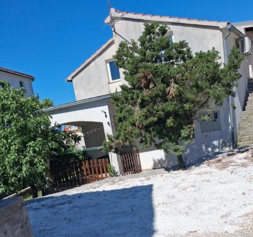a house with a tree in front of it at Laura Apartment in Tribunj