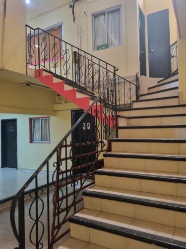 a set of stairs in a building with a red door at Hotel Posada Aurorita in Villahermosa