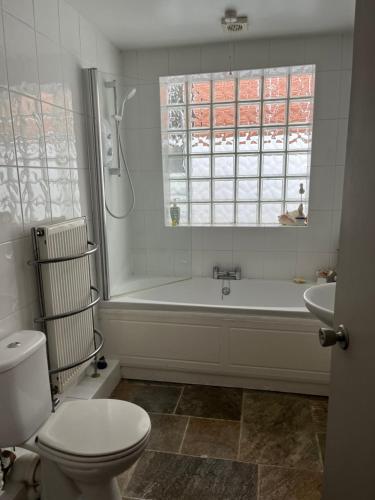 a bathroom with a tub and a toilet and a sink at Stunning coastal cottage in Worle
