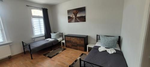 a room with two beds and a chair in it at Monterunterkunft Revant WE 2 in Arnstadt