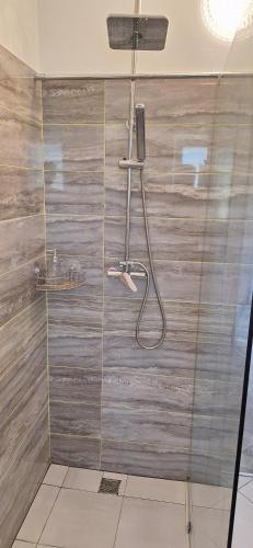 a bathroom with a shower with a wooden wall at Elizabeth in Komárom