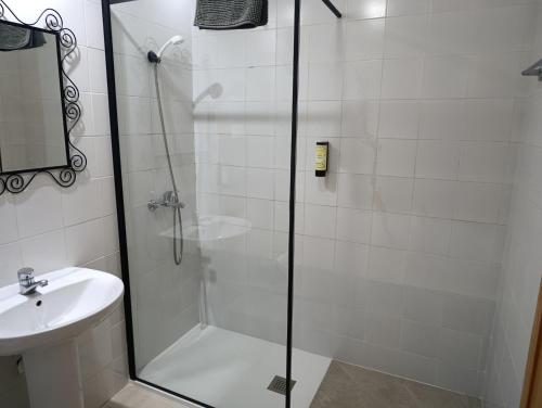 a shower with a glass door next to a sink at Complejo Rural La Belluga in Segorbe