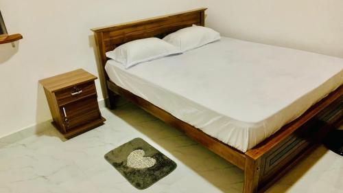 a bedroom with a bed with a wooden frame and a table at Mayon villa in Midigama East