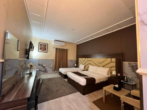 a hotel room with two beds and a television at Holiday Homes in Ras al Khaimah
