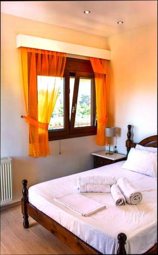 a bedroom with a bed with two towels on it at Anavissos pool appartment in Anavyssos