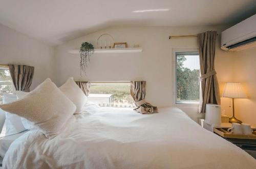 a large white bed in a bedroom with a window at SOL Glamping at Khao yai in Ban Nong Makha