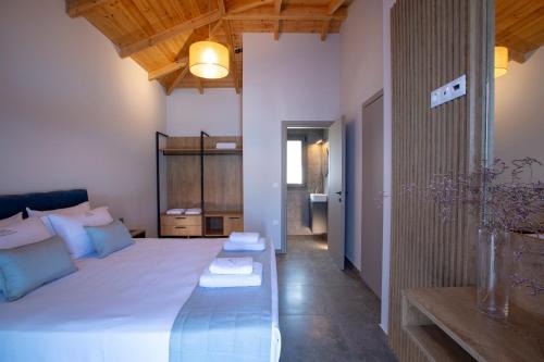 a bedroom with a large bed with a blue bench at Ionian Harmony Luxury Villas in Tsoukalades