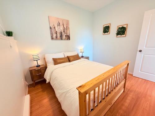 a bedroom with a large bed with a wooden floor at Ravenwood Stay With Ocean View in Victoria