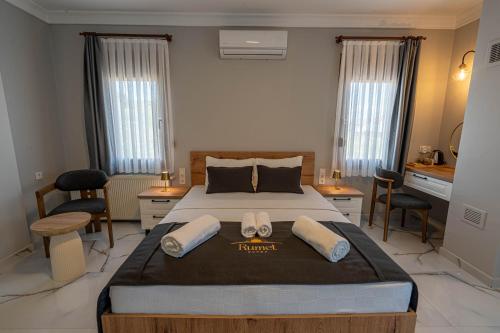 a bedroom with a large bed with two towels on it at Rumet Cunda Otel in Ayvalık