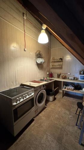 a kitchen with a stove and a washing machine at Ambra Apartaments Palanga in Palanga