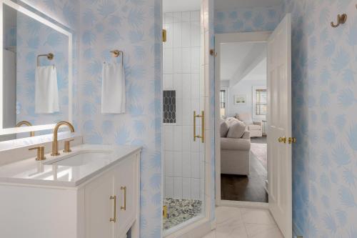 a bathroom with a sink and a shower with blue wallpaper at Elizabeth Pointe Lodge in Fernandina Beach