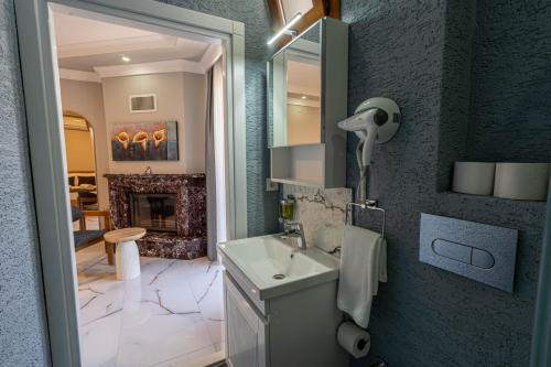 a bathroom with a sink and a fireplace at Rumet Cunda Otel in Ayvalık