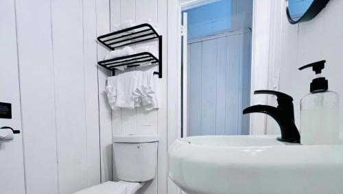a white bathroom with a sink and a toilet at Motel Luzerne in Lake Luzerne