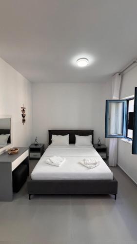 a bedroom with a bed and two tables in it at Drymades Ruci Rooms in Dhërmi