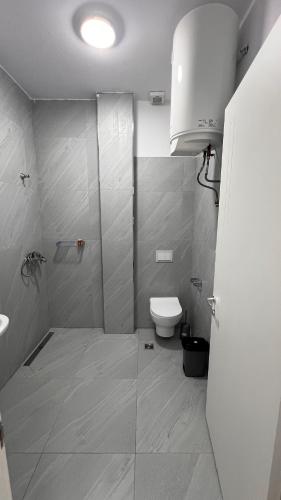 a white bathroom with a toilet and a sink at Drymades Ruci Rooms in Dhërmi