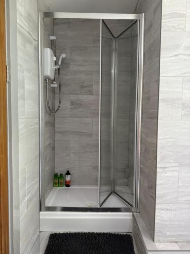 a shower with a glass door in a bathroom at Stonebarn New in Halton