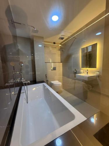 a large white bath tub in a bathroom with a toilet at Sportsman beach hotel in Calangute