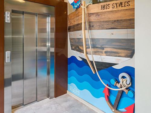 a elevator with a painting of a boat on the wall at Ibis Styles Lisboa Centro Liberdade NE in Lisbon