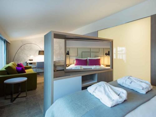 a bedroom with a large mirror above a bed at Mercure Krakow Stare Miasto in Krakow