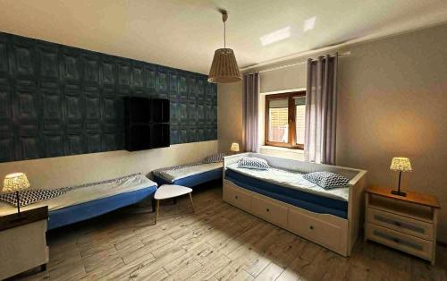 a room with two beds and a chair in it at Dom Mierzeja in Kąty Rybackie