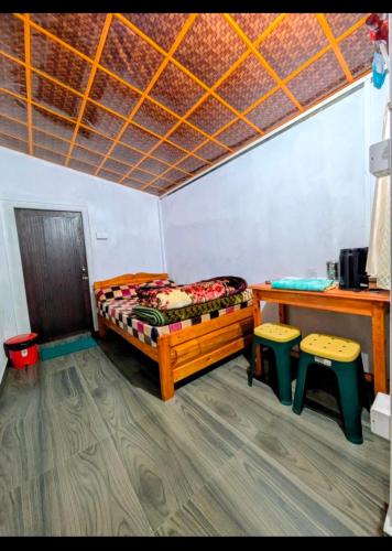a room with two beds and two stools in it at Peter and Paul Homestay in Shillong