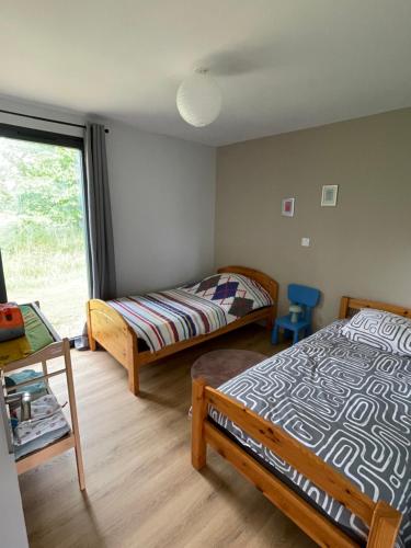 a bedroom with two beds and a window at Mur des Horizons in Plouigneau