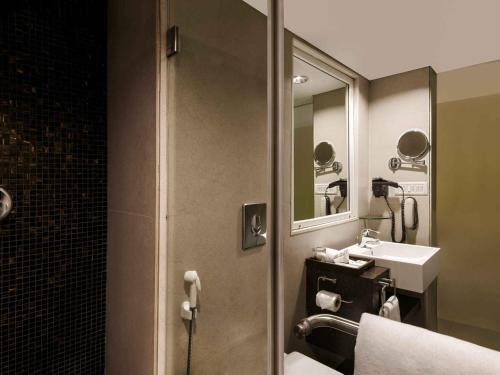 a bathroom with a sink and a mirror at Grand Mercure Vadodara Surya Palace in Vadodara