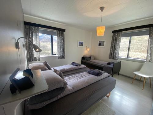 a bedroom with two beds and a couch at Sudavik guesthouse in Súðavík