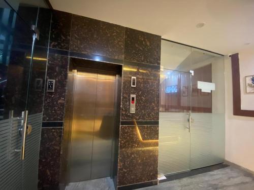 a elevator with a glass door in a building at hotel ak grand in Mangalore