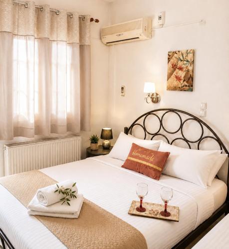 a bedroom with a large white bed with two glasses at Ιno Skiathos in Skiathos
