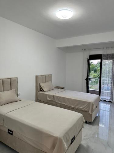 two beds in a white room with a window at Laki in Donji Štoj