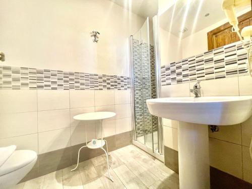 a white bathroom with a sink and a toilet at Simonetta's Rooms in Noto