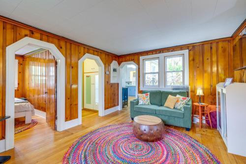 a living room with a green couch and a rug at Blocks to Beach & Eats! Elk Rapids 'Cozy Cottage' in Elk Rapids