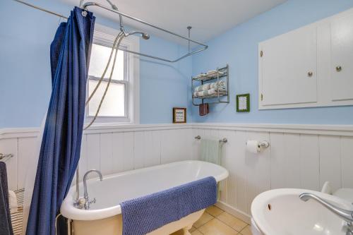 a bathroom with a bath tub and a sink at Blocks to Beach & Eats! Elk Rapids 'Cozy Cottage' in Elk Rapids