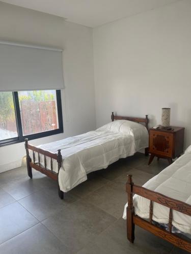 two beds sitting in a room with a window at En el Centro in Gualeguaychú