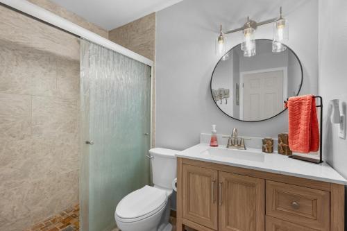 a bathroom with a toilet and a sink and a mirror at Kona Mansions#226 in Kailua-Kona