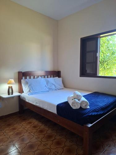 a bedroom with a bed with two towels on it at Casa Bella Itaúna Suites in Saquarema