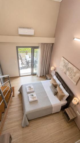 a bedroom with a large bed and a balcony at Danny Arz Apartments in Iraklitsa