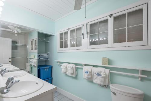 a bathroom with a sink and a toilet and cabinets at KW41 Amelia House in Key West