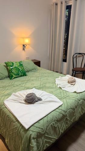 a green bed with two towels on top of it at Amoite hotel boutique in Nuestra Señora del Rosario de Caa Catí