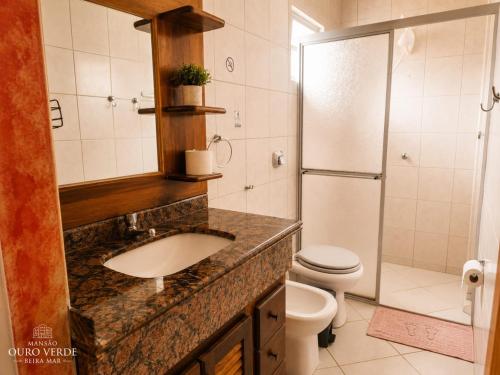 a bathroom with a sink and a toilet and a shower at Mansão Ouro Verde Beira Mar in Piçarras