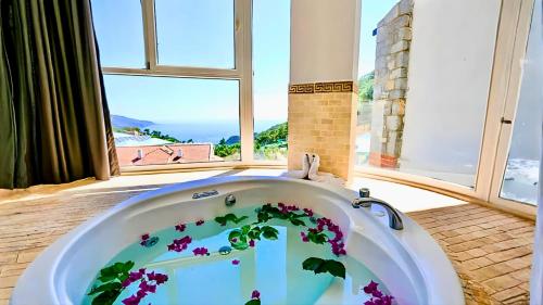 a bathroom with a white tub with purple flowers in it at Azure Palm Resort in Oludeniz
