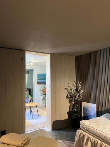 a bedroom with a bed and a table with flowers at Mysig Lägenhet in Varberg