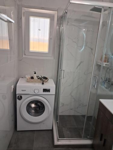 a bathroom with a washing machine and a shower at S&A New Chile AXD in Alexandroupoli