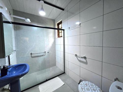a bathroom with a blue sink and a shower at Casa Amarela, Refúgio na natureza Rota do vinho in São Roque