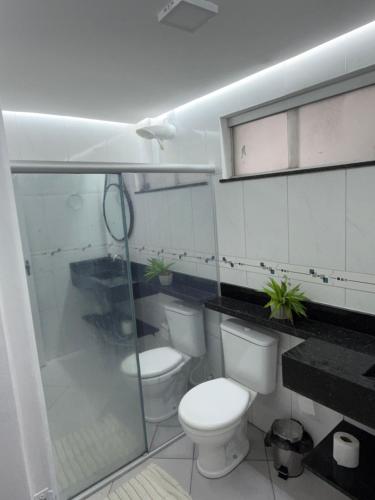 a white bathroom with two toilets and a shower at Premium Feira ap 01 - Ar - Feiraguay - 24H check-in in Feira de Santana