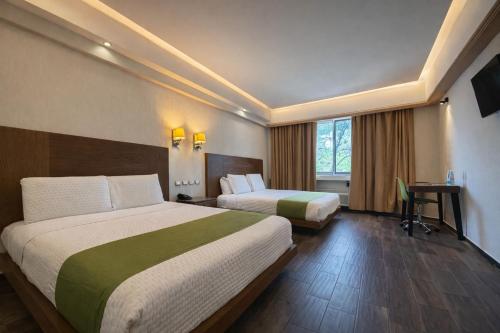a hotel room with two beds and a desk at Hotel Diana del Bosque by DOT Urban in Morelia