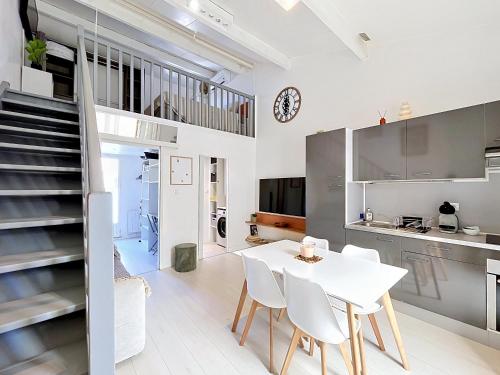 a kitchen and dining room with a white table and chairs at Maison village accès mer et commerces à pieds in Le Barcarès